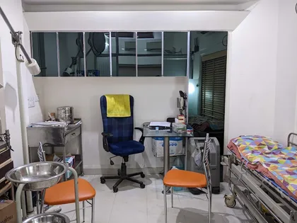 A small consultation room inside the clinic, with an exam table and cabinets.